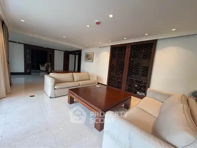 Spacious living room with elegant wooden furniture and modern lighting.