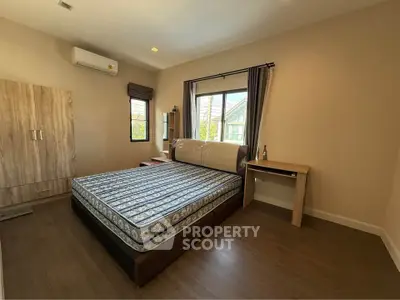Spacious bedroom with large bed and natural light, featuring modern decor and wooden flooring.