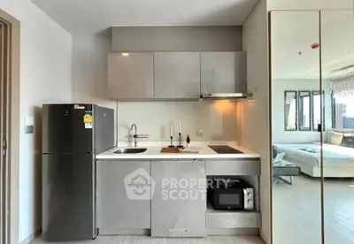 Modern compact kitchen with sleek cabinetry and integrated appliances in a stylish apartment.