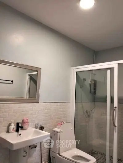 Modern bathroom with shower enclosure and sleek fixtures in a stylish real estate property.