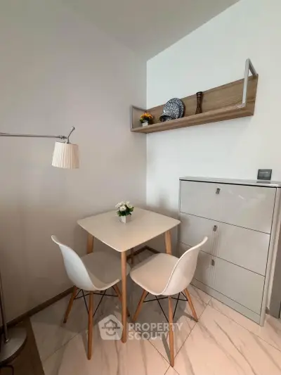 Modern dining nook with sleek table and chairs, stylish shelving, and elegant decor in a cozy apartment.