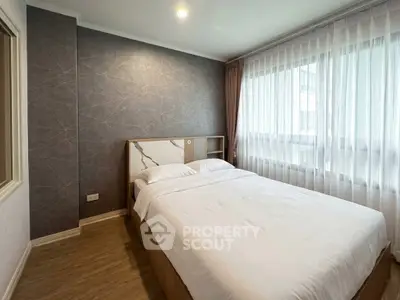 Modern bedroom with elegant decor and large window in a stylish apartment.