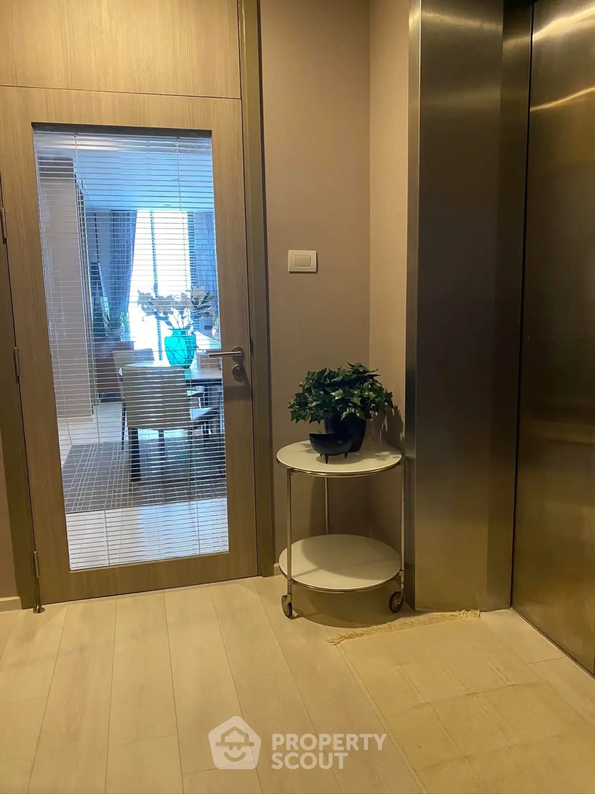 Elegant elevator lobby with stylish decor and glass door entryway