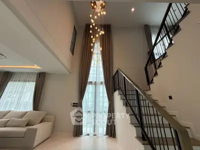 Elegant modern living room with high ceiling and stylish staircase