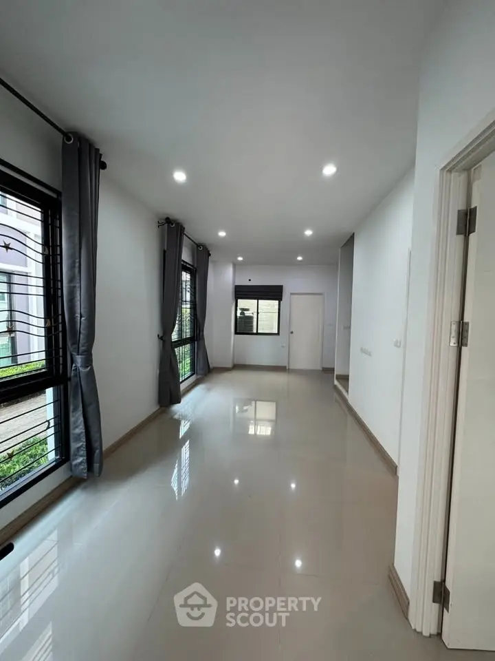 Spacious modern living room with large windows and sleek tile flooring