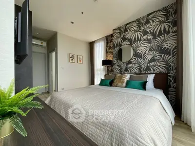 Stylish bedroom with modern decor and elegant wallpaper, featuring a cozy bed and natural light.