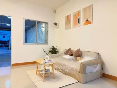 Modern living room with stylish decor and natural light, featuring a cozy sofa and contemporary artwork.