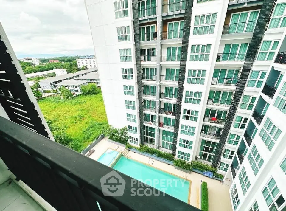 Stunning high-rise apartment view with pool and lush greenery, perfect for urban living.
