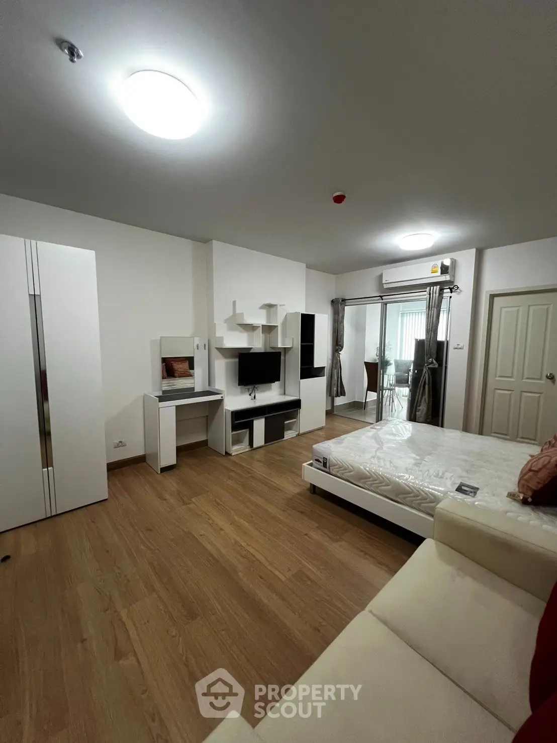 Modern studio apartment with sleek furnishings and wooden flooring
