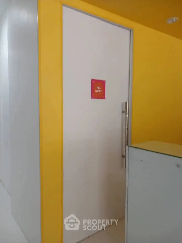 Modern office entrance with vibrant yellow walls and sleek door handle