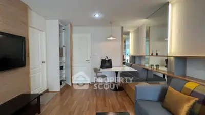 Modern living room with sleek design, featuring a cozy sofa, wall-mounted TV, and stylish dining area.