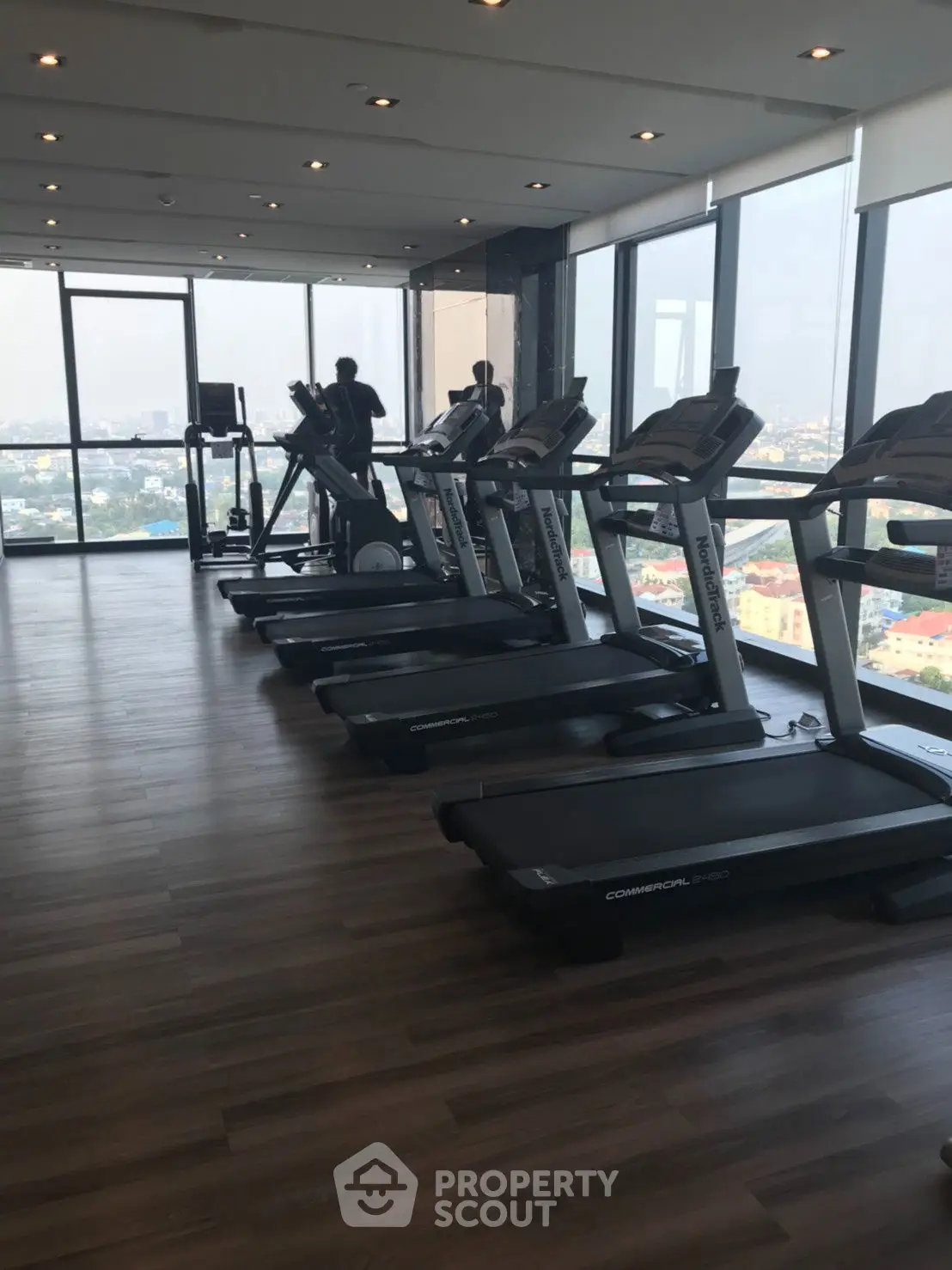 Modern gym with panoramic city views and state-of-the-art equipment.