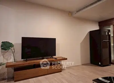 Modern living room with sleek TV stand and refrigerator, showcasing minimalist design and functionality.