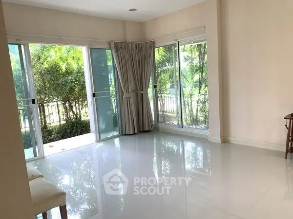 Spacious living room with large windows and garden view
