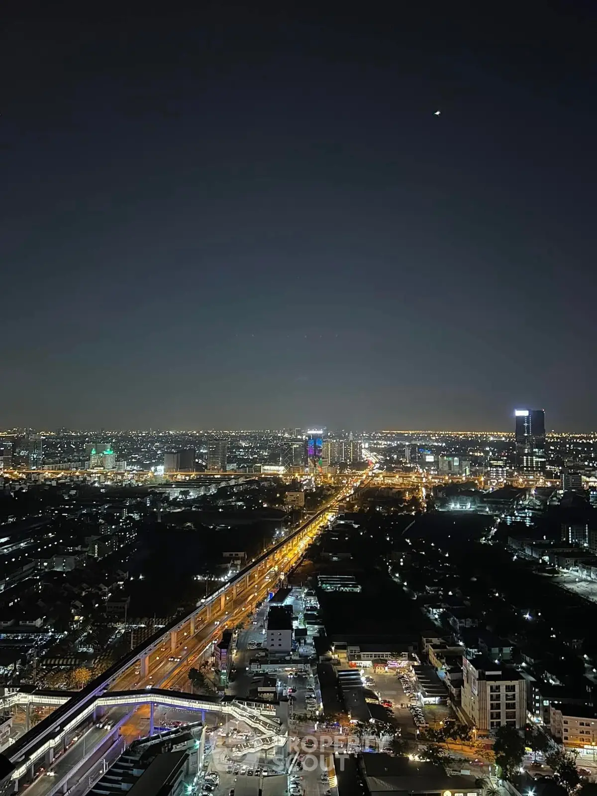 Stunning cityscape view from high-rise building at night, showcasing vibrant city lights and expansive skyline.