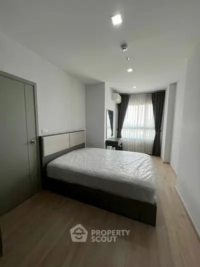 Spacious bedroom with modern design and large window for natural light