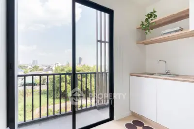 Modern kitchen with balcony view, sleek design and ample natural light, perfect for urban living.