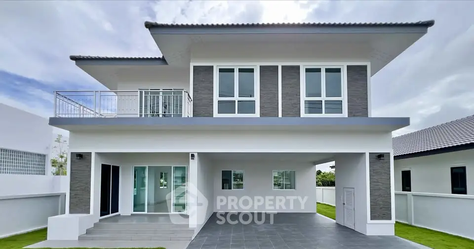 Modern two-story house with large windows and spacious balcony, showcasing contemporary architecture and sleek design.