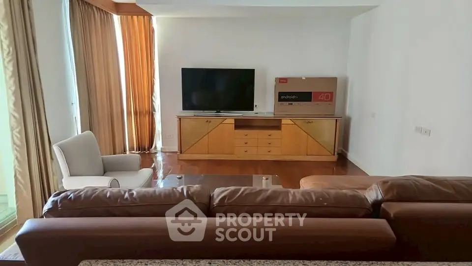Spacious living room with modern furniture and large TV, perfect for relaxation and entertainment.