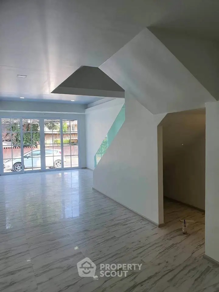 Spacious modern living room with large windows and sleek marble flooring