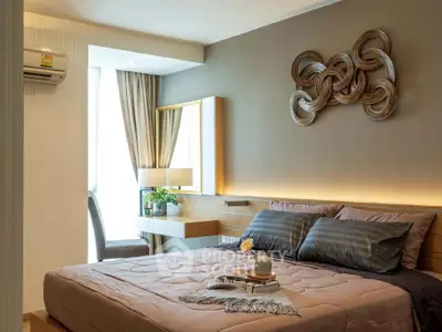 Elegant bedroom with modern decor and natural light, featuring a stylish wall art and cozy bedding.