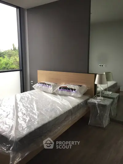 Modern bedroom with large window and minimalist decor in a stylish apartment.