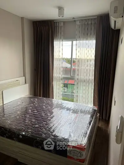 Cozy bedroom with large window and modern furnishings in a stylish apartment.