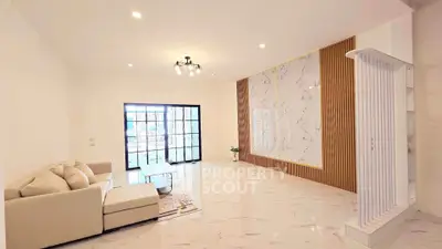 Spacious modern living room with elegant marble accents and cozy seating area.