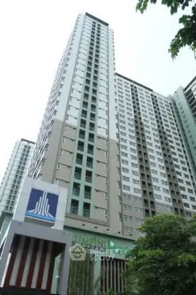 Modern high-rise apartment building with sleek design and lush greenery.