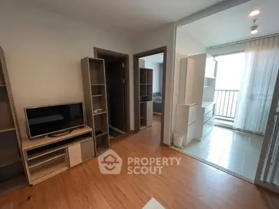 Modern living room with wooden flooring and balcony access in a stylish apartment.