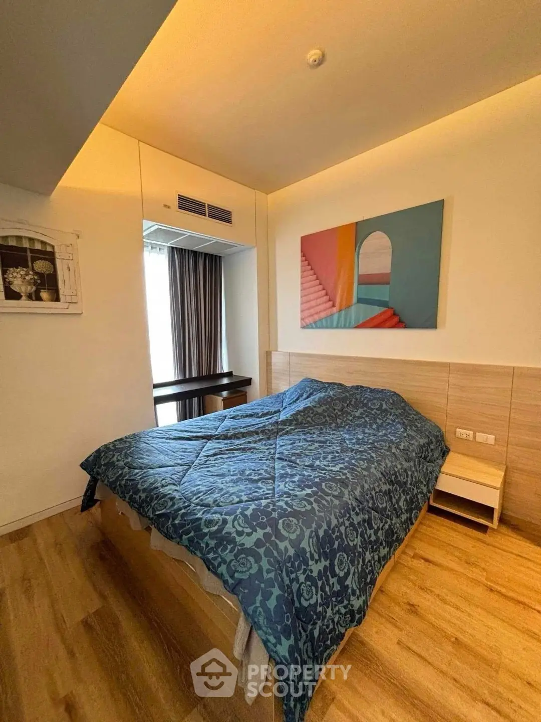 Modern bedroom with stylish decor and cozy ambiance, featuring a large bed and wooden flooring.