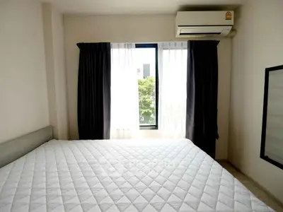 Bright bedroom with large window and air conditioning in modern apartment