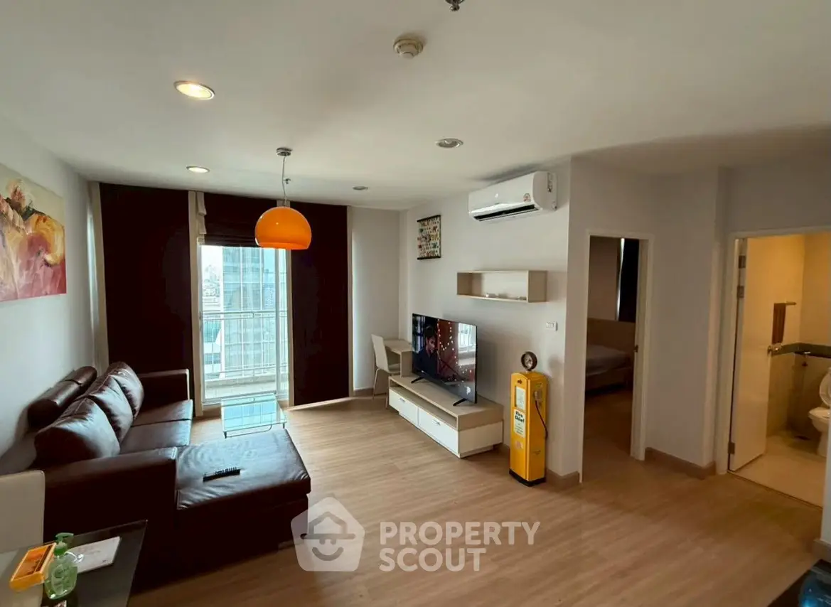 Modern living room with leather sofa and balcony view in a stylish apartment.