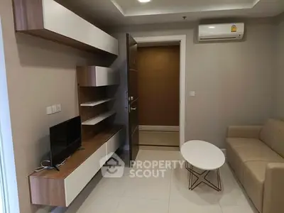 Modern living room with sleek furniture and wall-mounted TV in a cozy apartment.