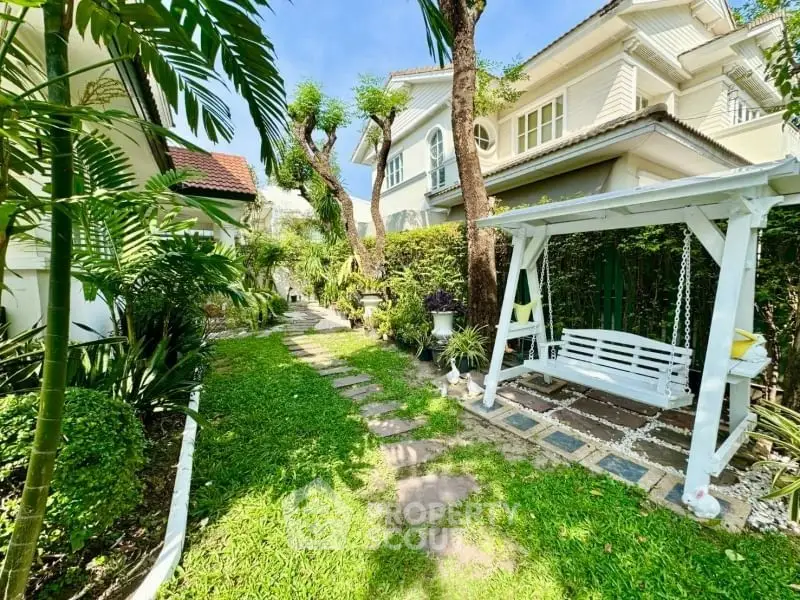 Charming garden with swing in a lush green backyard of a beautiful house