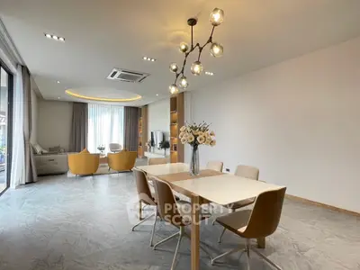 Spacious modern living and dining area with elegant lighting and large windows.