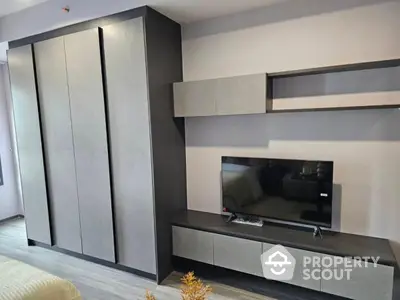 Modern bedroom with sleek wardrobe and TV unit, perfect for stylish living.