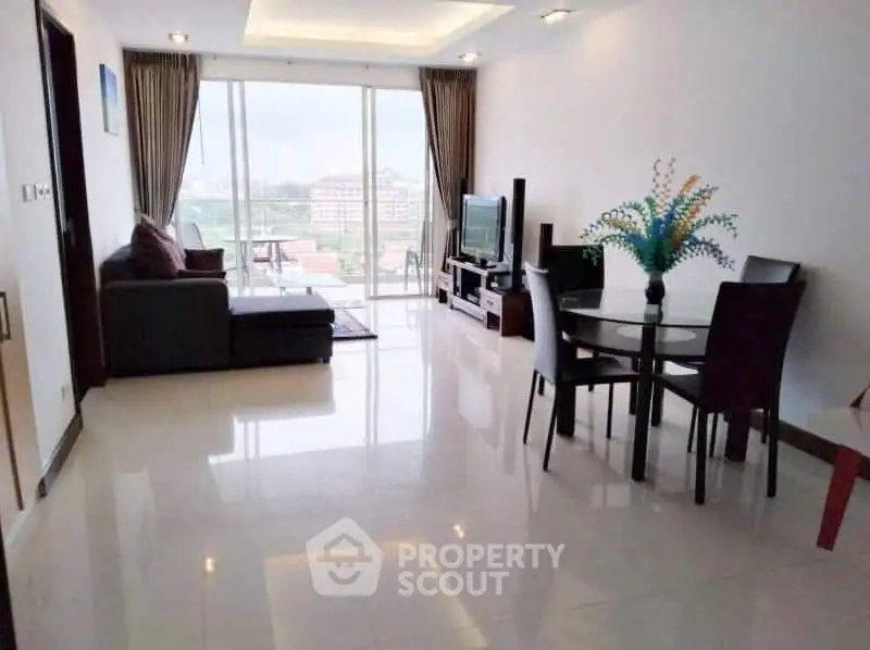 Spacious living room with modern decor and large windows offering a stunning city view.