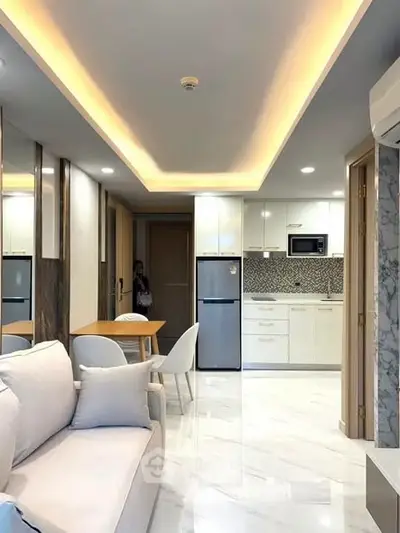 Modern open-plan living room and kitchen with sleek design and ambient lighting