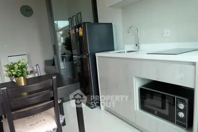 Modern kitchen with sleek appliances and dining area in stylish apartment