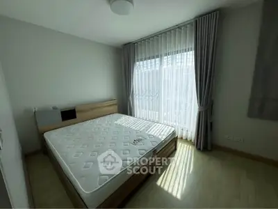 Bright bedroom with large window and modern furnishings in a stylish apartment.