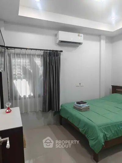 Cozy bedroom with air conditioning and natural light, perfect for relaxation.