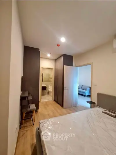 Modern bedroom with ensuite bathroom and cozy living area in a stylish apartment.