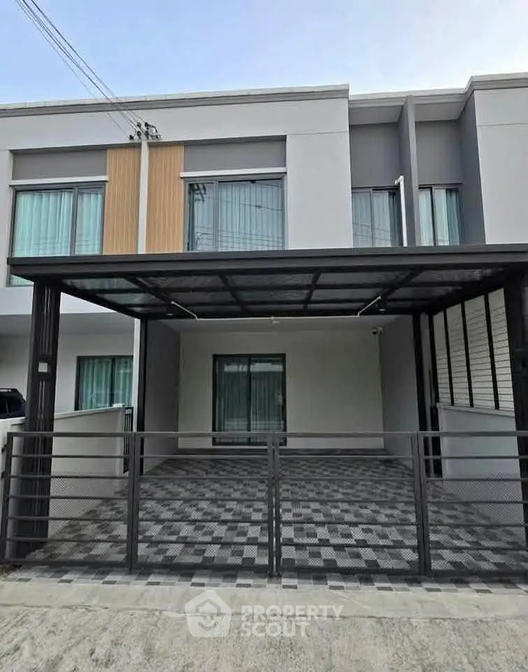 Modern townhouse exterior with covered parking and sleek design