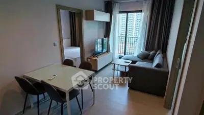 Modern living room with dining area and balcony view in a stylish apartment.