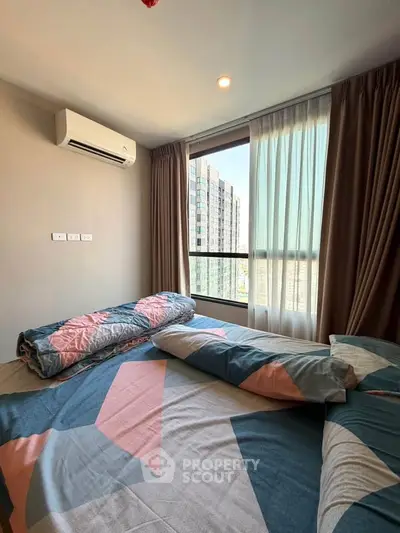 Cozy bedroom with large window and modern decor in urban apartment