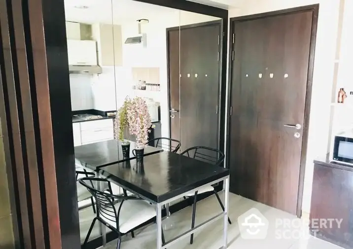 Modern kitchen with open layout, sleek black dining set, and ample natural light, perfect for culinary enthusiasts seeking a stylish cooking space.