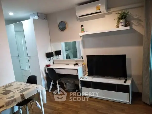 Modern living room with TV, air conditioning, and stylish furniture