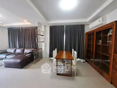 Spacious living room with modern furniture and large windows in a stylish apartment.