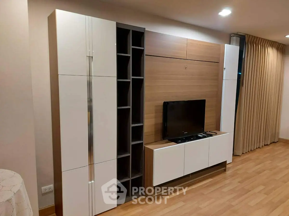 Modern living room with sleek entertainment center and wooden flooring